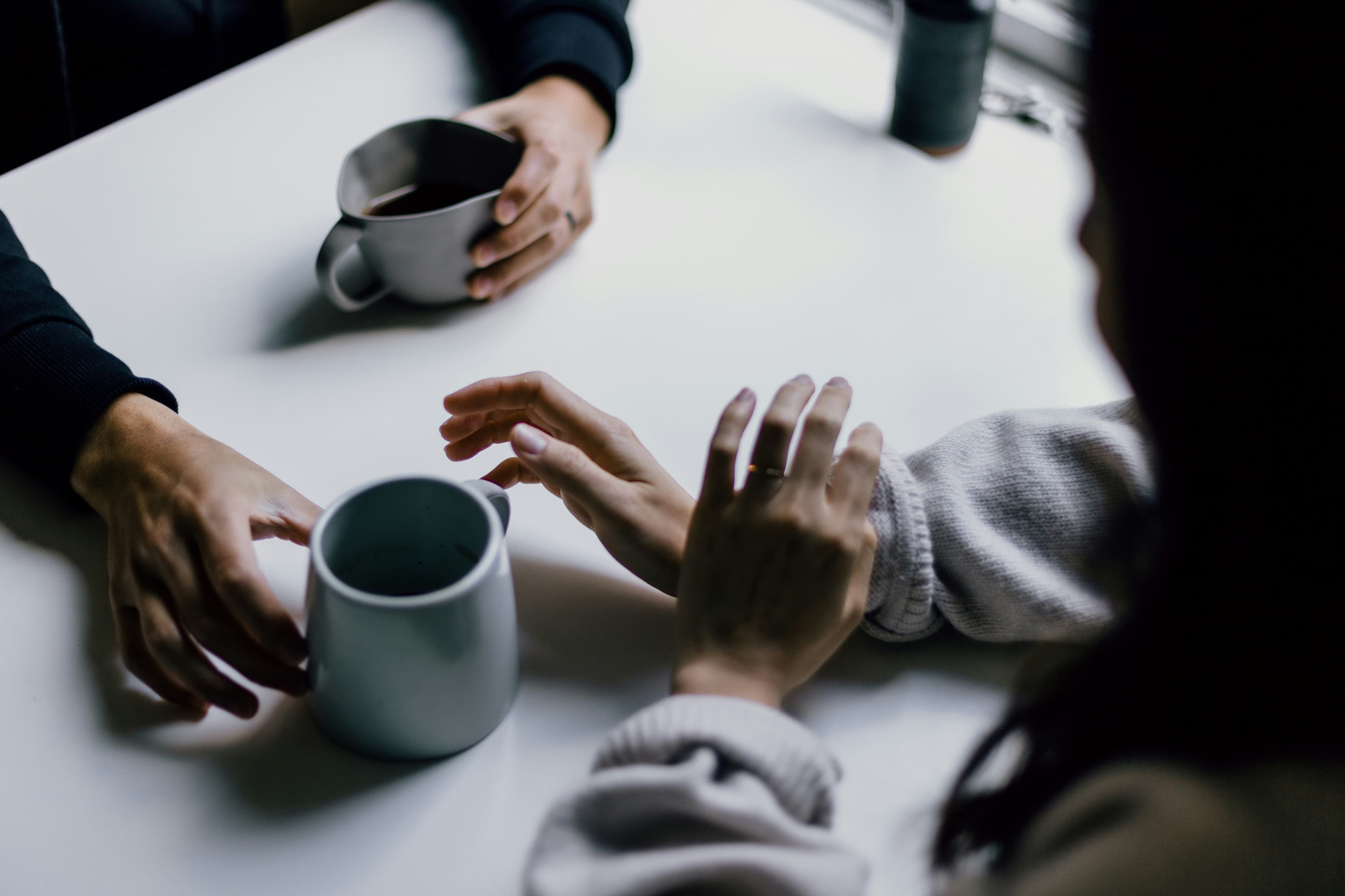 Two people talking over coffee at a table
